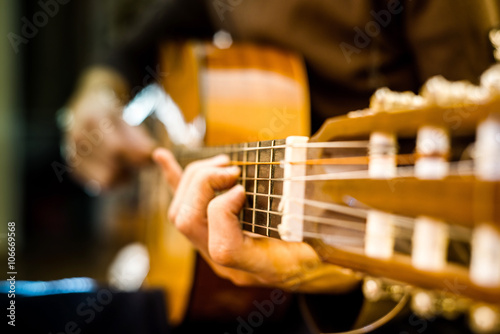 the young guy playing an acoustic guitar. Shooting backlit