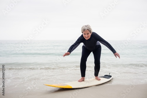 Senior woman surfing on surfboard