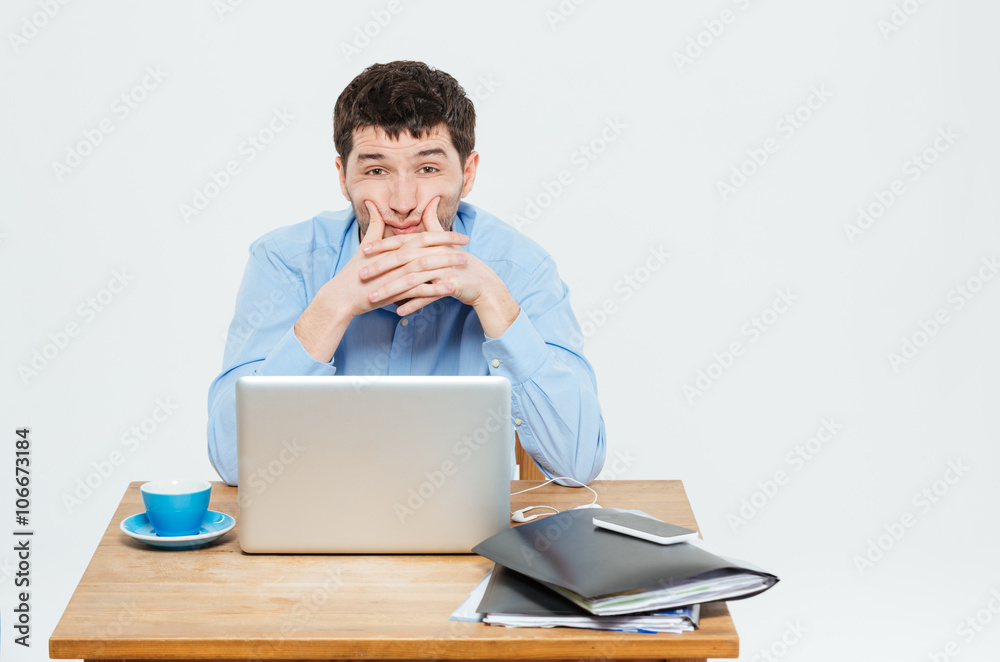 Tired businessman sitting at the table with laptop Tired businessman sitting at the table with laptop