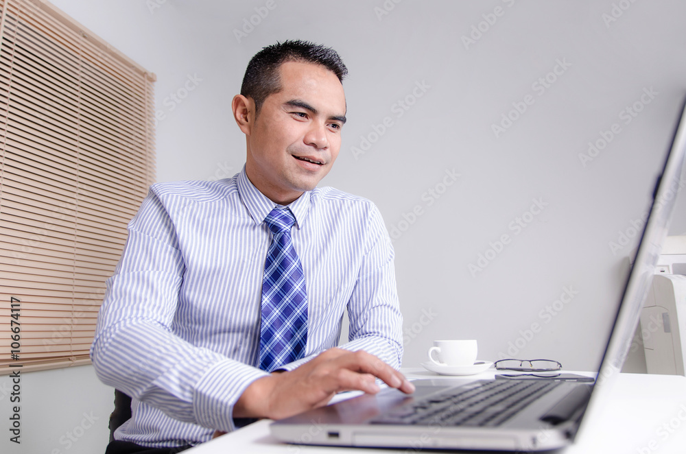 Happy smile business man using laptop computer in office Happy smile business man using laptop computer in office