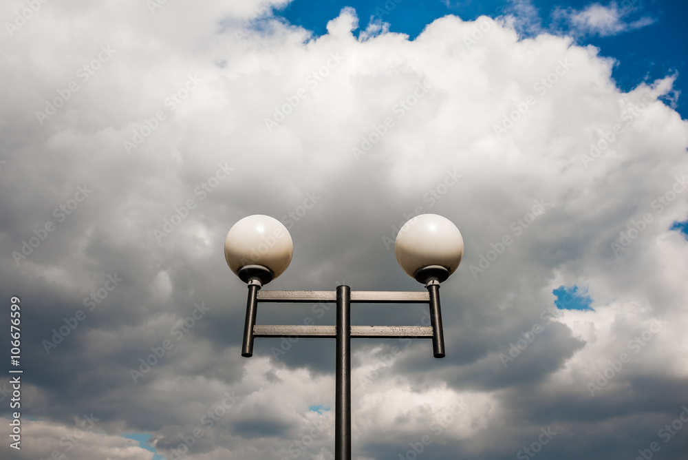 Lamppost against the blue sky with clouds