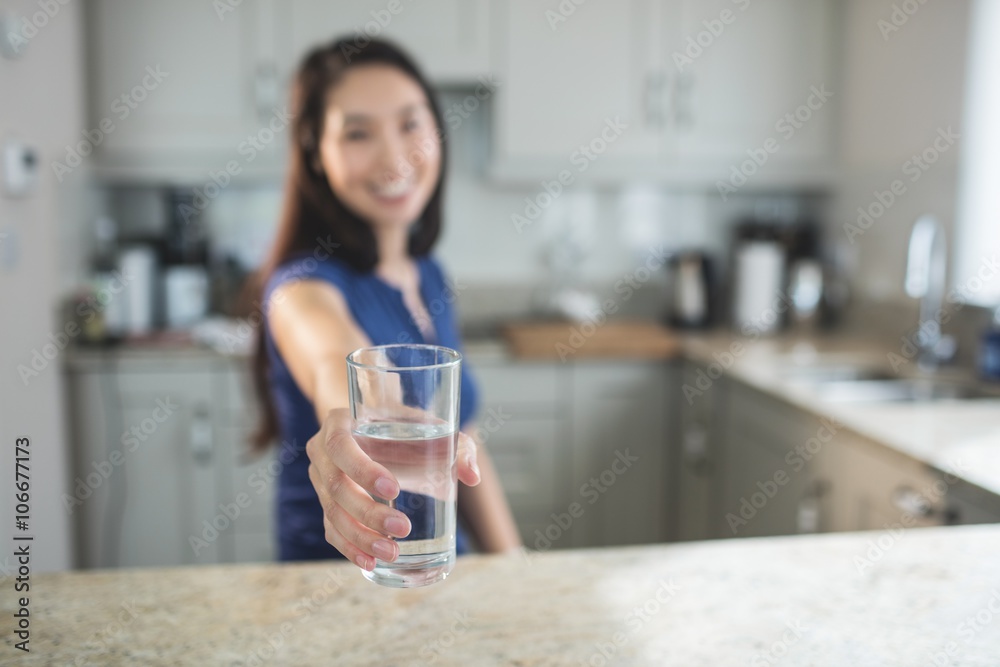 Young woman holding a glass of water in kitchen Young woman holding a glass of water in kitchen