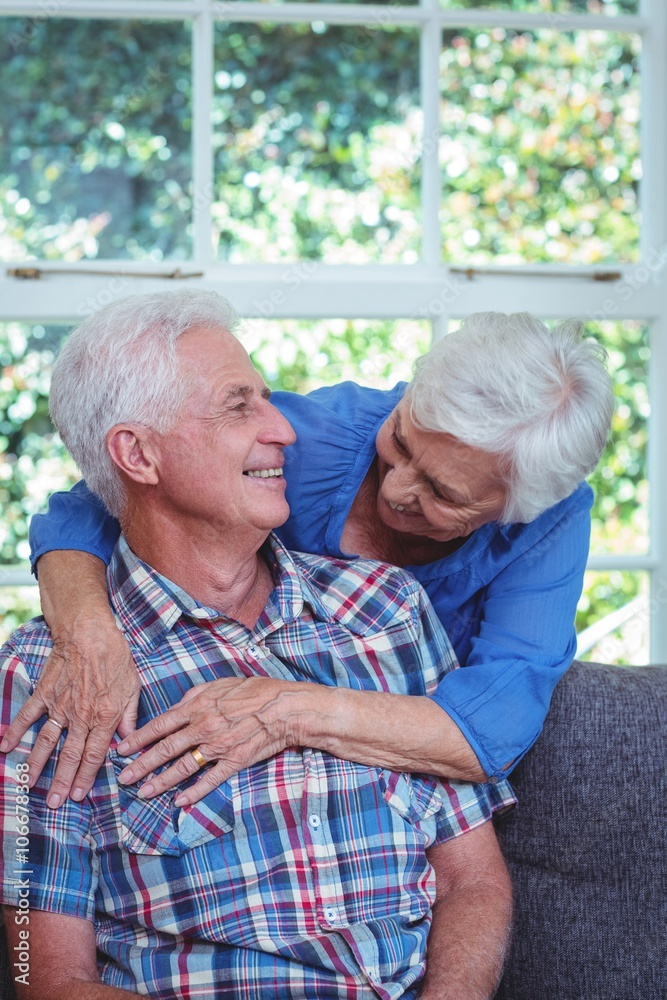 Happy wife embracing while looking at senior man Happy wife embracing while looking at senior man
