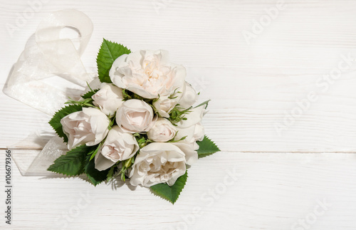 white roses on white table.top view
