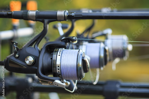 Three fishing rods with reel set up on holder