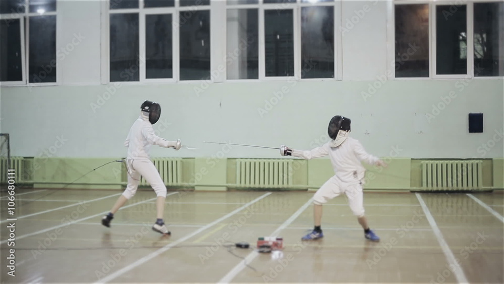 Young guys fencers practicing fencing duel Young guys fencers practicing fencing duel