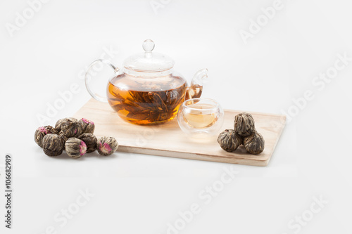 exotic green tea with flowers in glass teapot and cup isolated on studio background