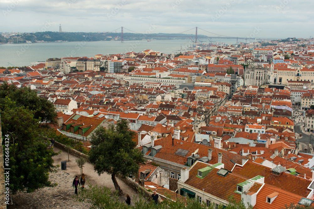 Vista from Sao Jorge Castle over Lisbon's Baixa neighbourhood with Tagus river, Cristo Rei statue and 25 de Abril bridge.