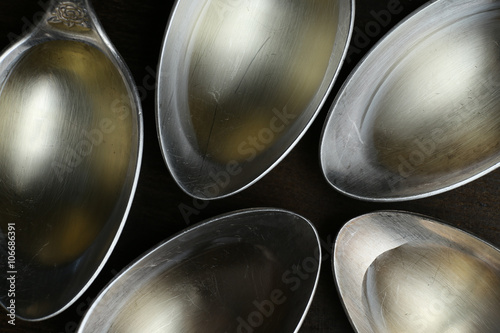 Olive oil in the spoons on wooden background. Close up. Top view