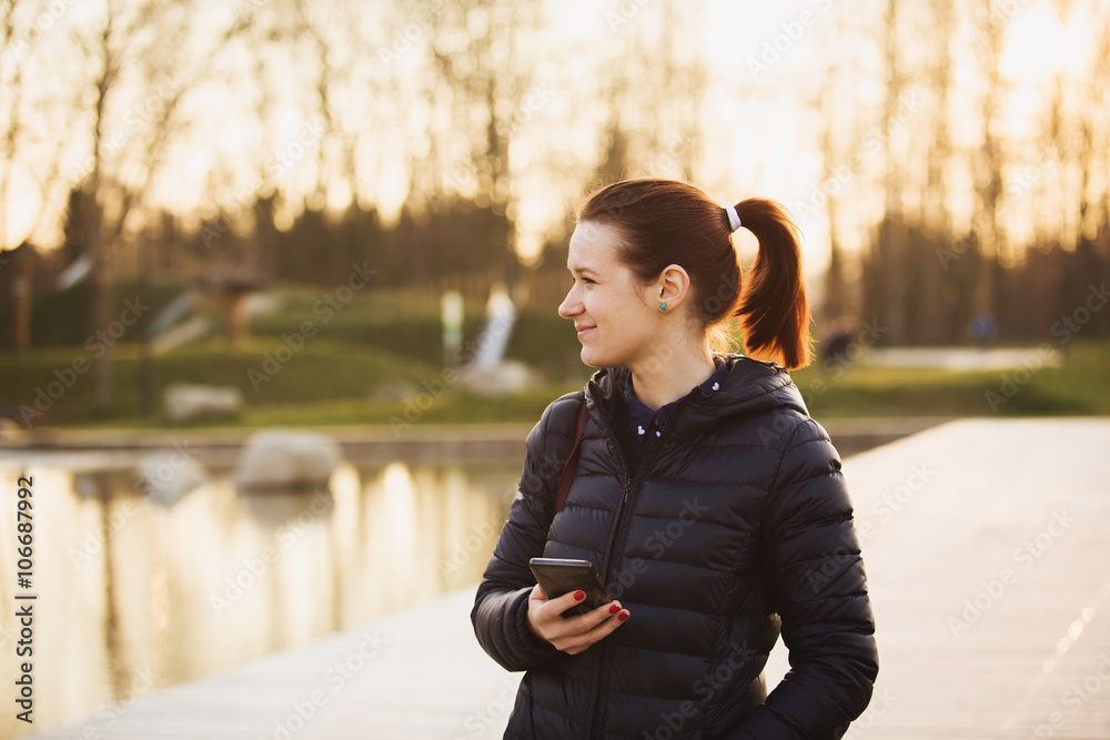 Enjoyment-Smiling young girl woman with mobile phone in a city .Young smiling student girl outdoors talking on cell smart phone.Life style.City Enjoyment-Smiling young girl woman with mobile phone in a city .Young smiling student girl outdoors talking on cell smart phone.Life style.City