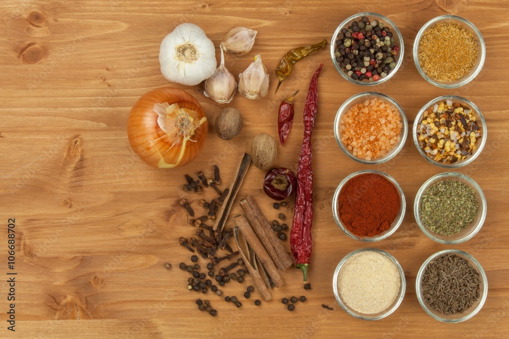 The joy of cooking, preparation of spices. Various kinds of spices on a wooden board. Food preparation. Spices on the kitchen table.
