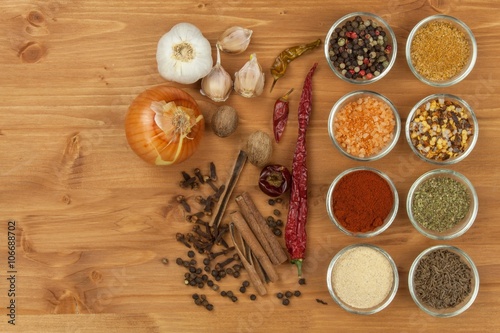 Fototapeta Naklejka Na Ścianę i Meble -  The joy of cooking, preparation of spices. Various kinds of spices on a wooden board. Food preparation. Spices on the kitchen table.
