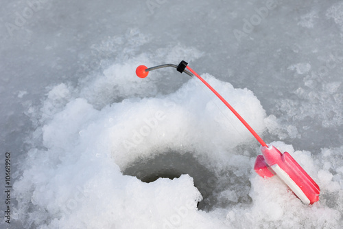 winter fishing symbol. rod on the hole closeup