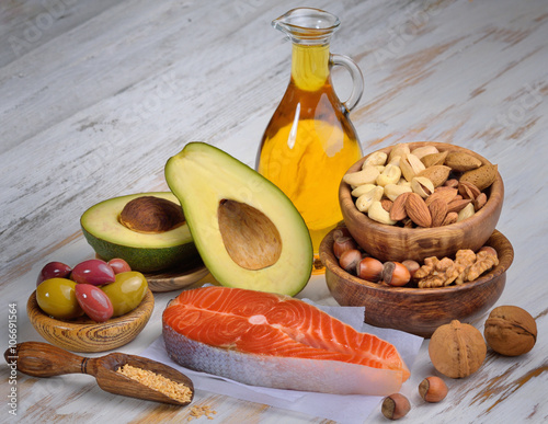 Selection of healthy fat sources on white wood background. 