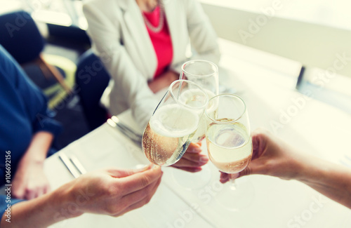 close up of women clinking champagne at restaurant