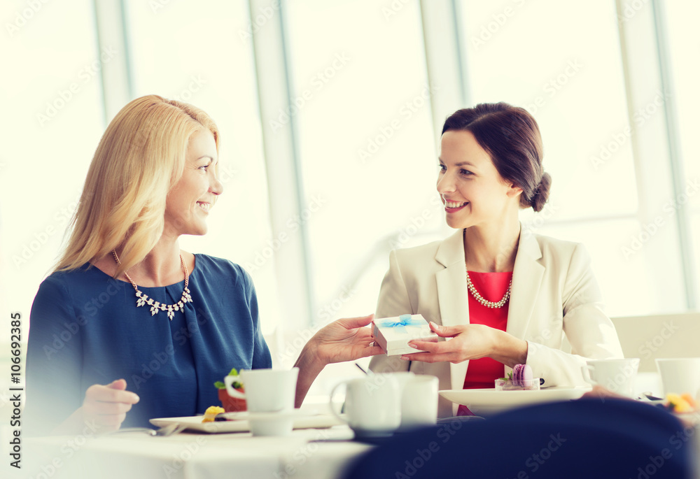 happy women giving birthday present at restaurant happy women giving birthday present at restaurant