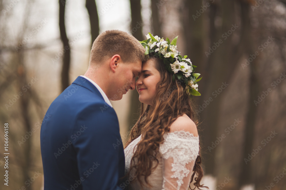 Happy wedding couple, bride and groom walking in the autumn forest, park