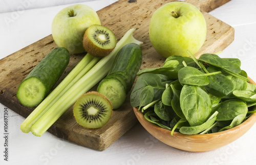 Ingredients for smoothie: spinach, kiwi, apple, celery on a whit