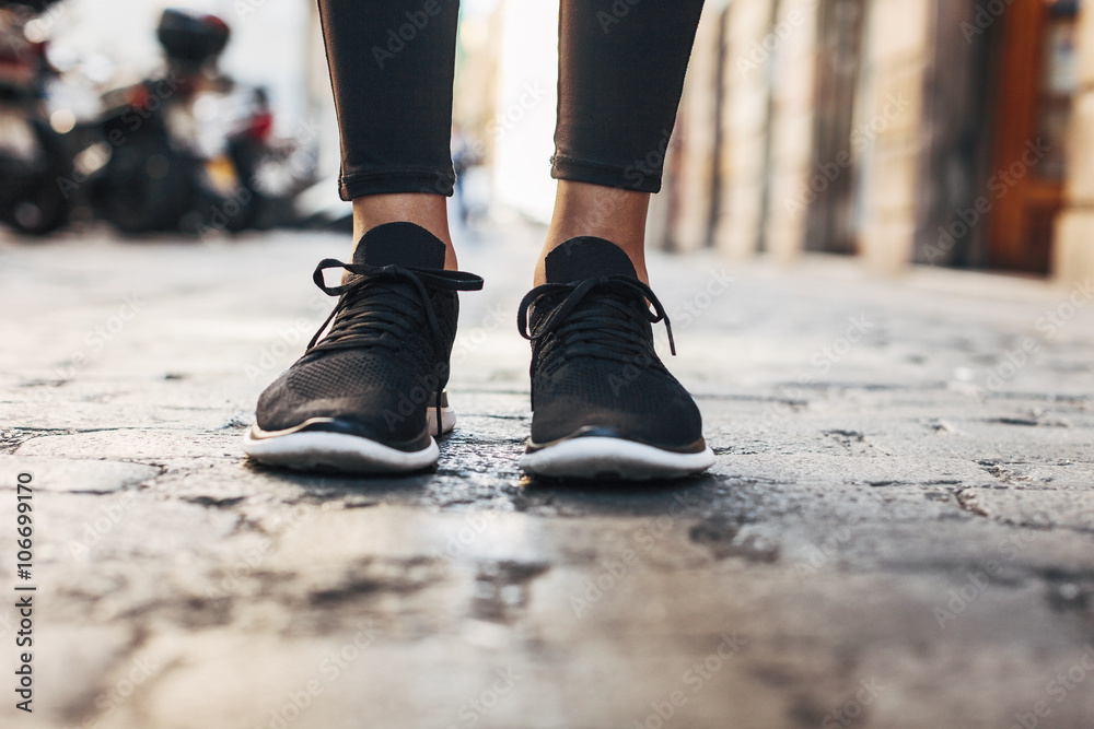 Black sneakers of sportive young woman, close-up Black sneakers of sportive young woman, close-up
