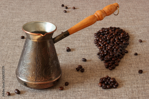 Coffee Turk and coffee beans in the form of an exclamation mark on sack cloth background.