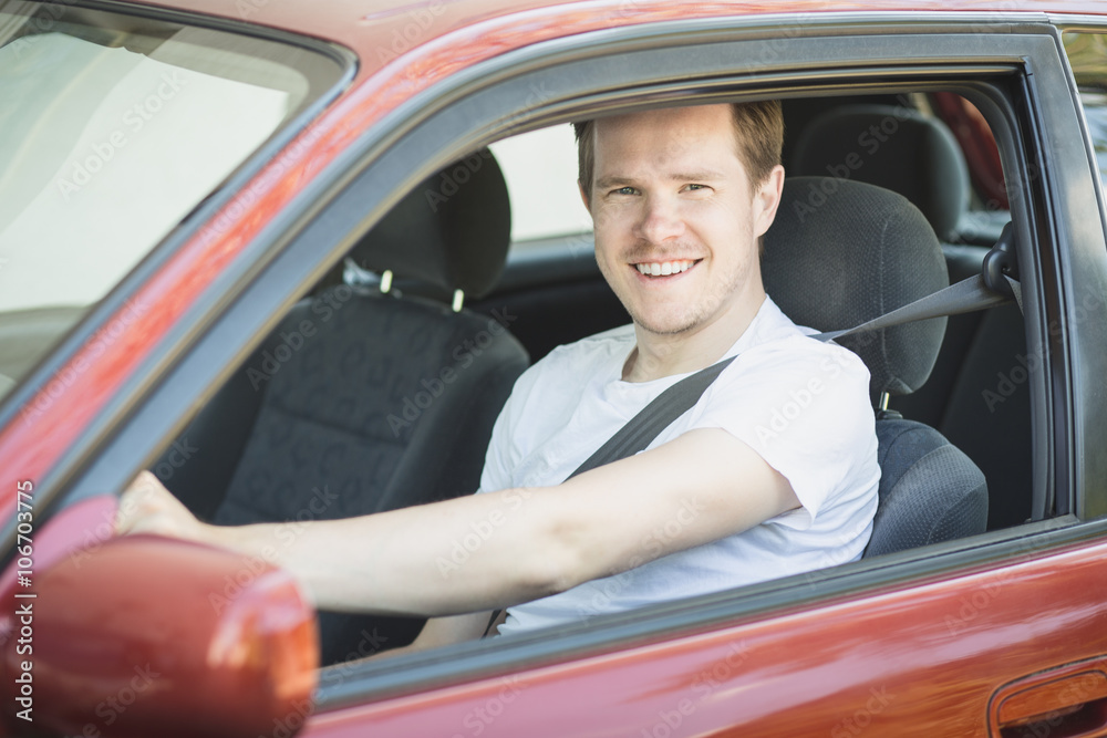 Junger Mann sitzt im Auto