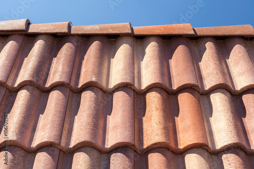 Red roof tile pattern over blue sky