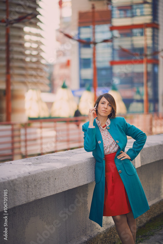 Business woman portrait outdoors talking at the phone/working on notebook with modern background © chika_milan