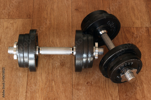 Iron dumbbells on hardwood floor. Weightlifting training concept.