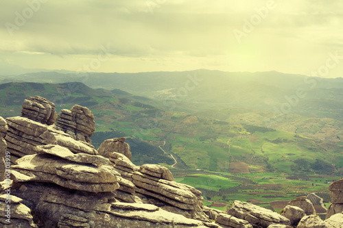 View of karst rocks with farmlands in the background. El Torcal, Antequera. Spain. photo