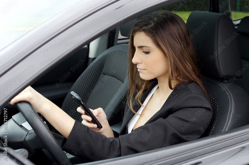 Business woman texting message with cell phone sitting in car working