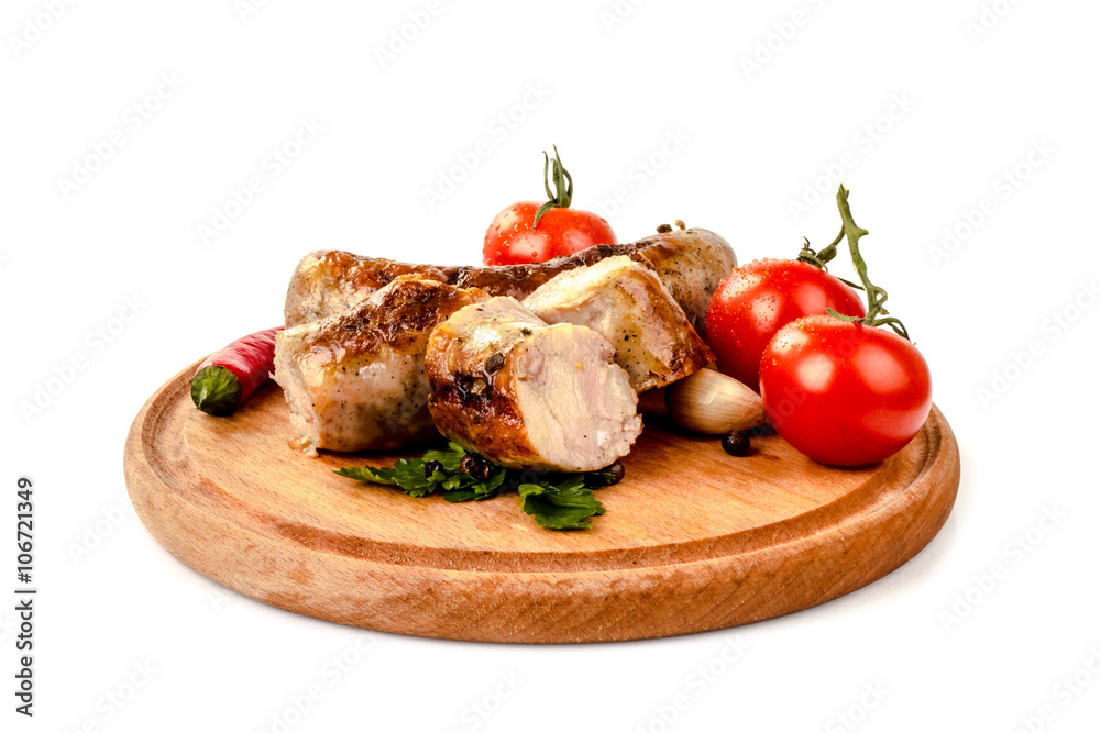fried pork sausages on a barbecue on a wooden plate with cherry tomatoes and hot peppers fried pork sausages on a barbecue on a wooden plate with cherry tomatoes and hot peppers