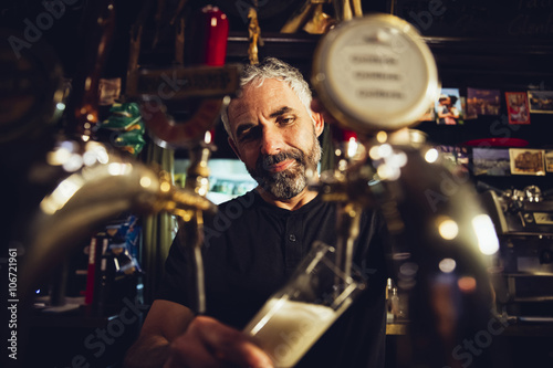 Man tapping beer in an Irish pub photo