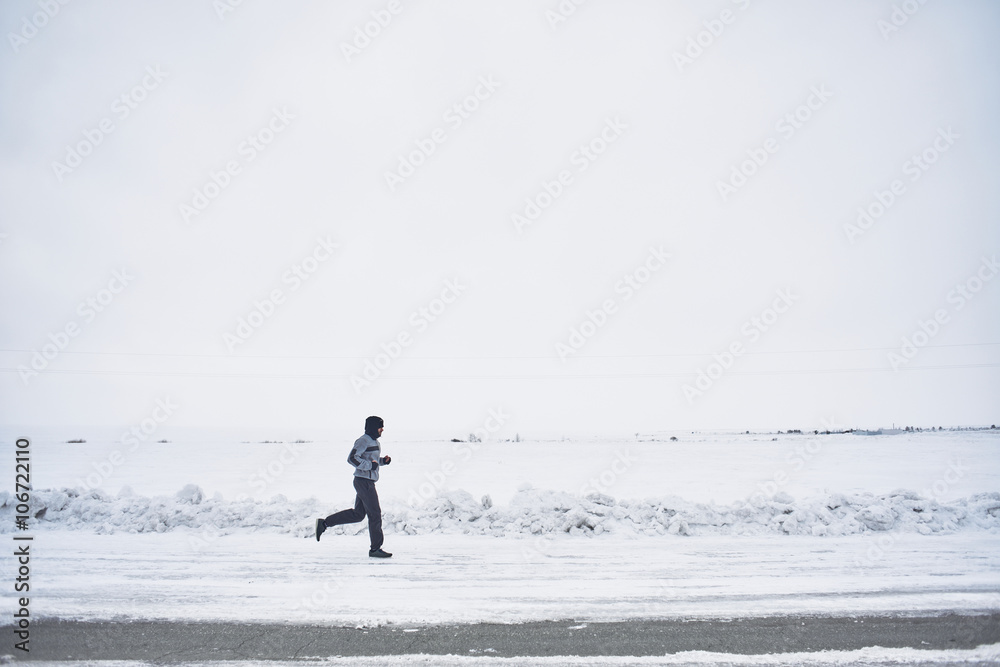 The athlete runs in the winter on the road