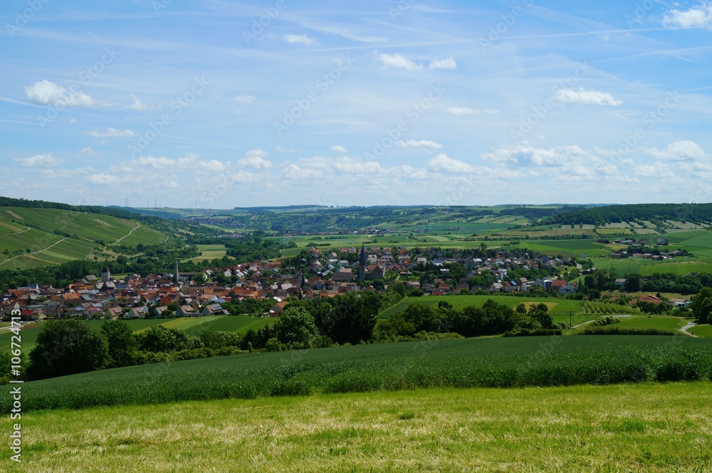 View of the rural, historic village of Markelsheim on a plain surrounded by green hills. Markelsheim, Taubertal, Franconia in Bavaria, Germany.