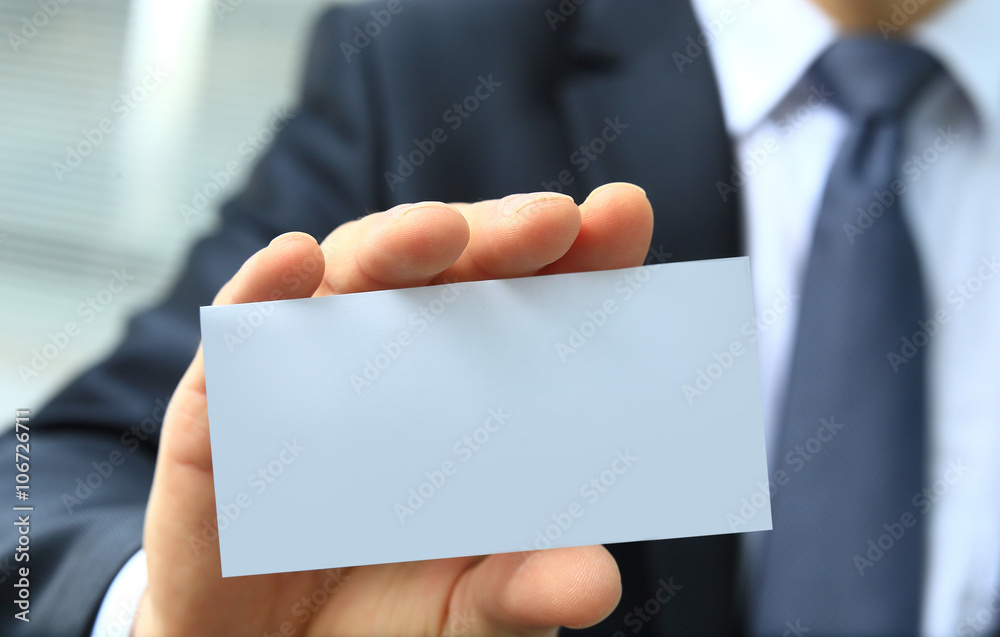 Man's hand showing business card - closeup shot on grey background Man's hand showing business card - closeup shot on grey background