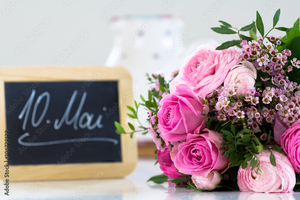 Obraz premium A bouquet of flowers and a slate with a text on Mother's Day