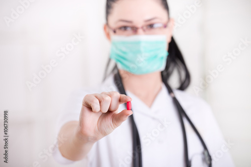 Woman with mask showing pill
