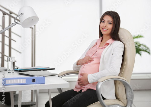 Pregnant woman sitting at h...