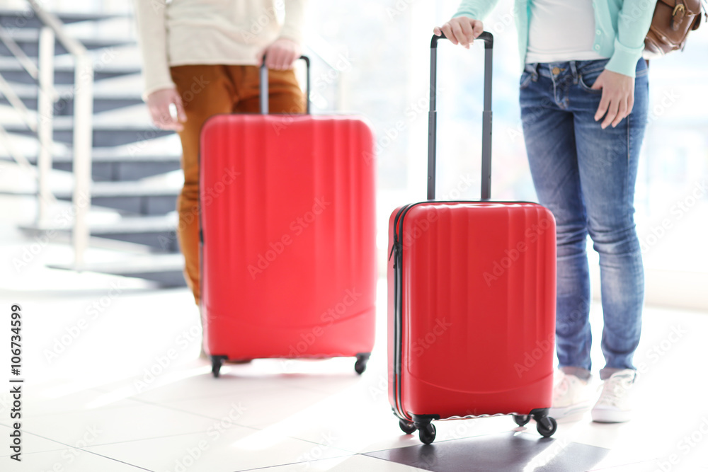 Couple waiting with large red suitcases, close up Couple waiting with large red suitcases, close up