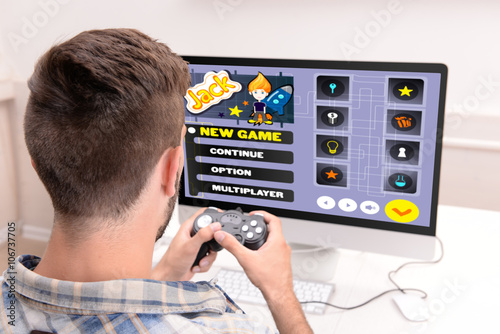 Young man playing computer ...