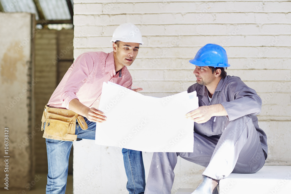 Construction worker and foreman discussing building plan Construction worker and foreman discussing building plan