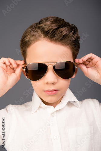 Close up portrait of little serious cool boy in glasses