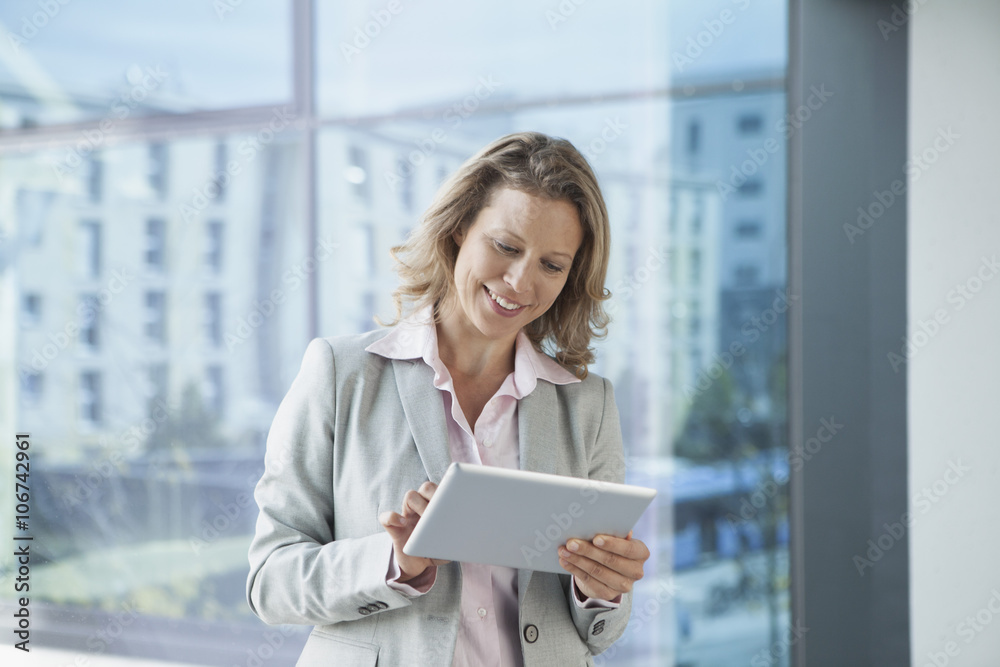 Smiling businesswoman using digital tablet in office Smiling businesswoman using digital tablet in office