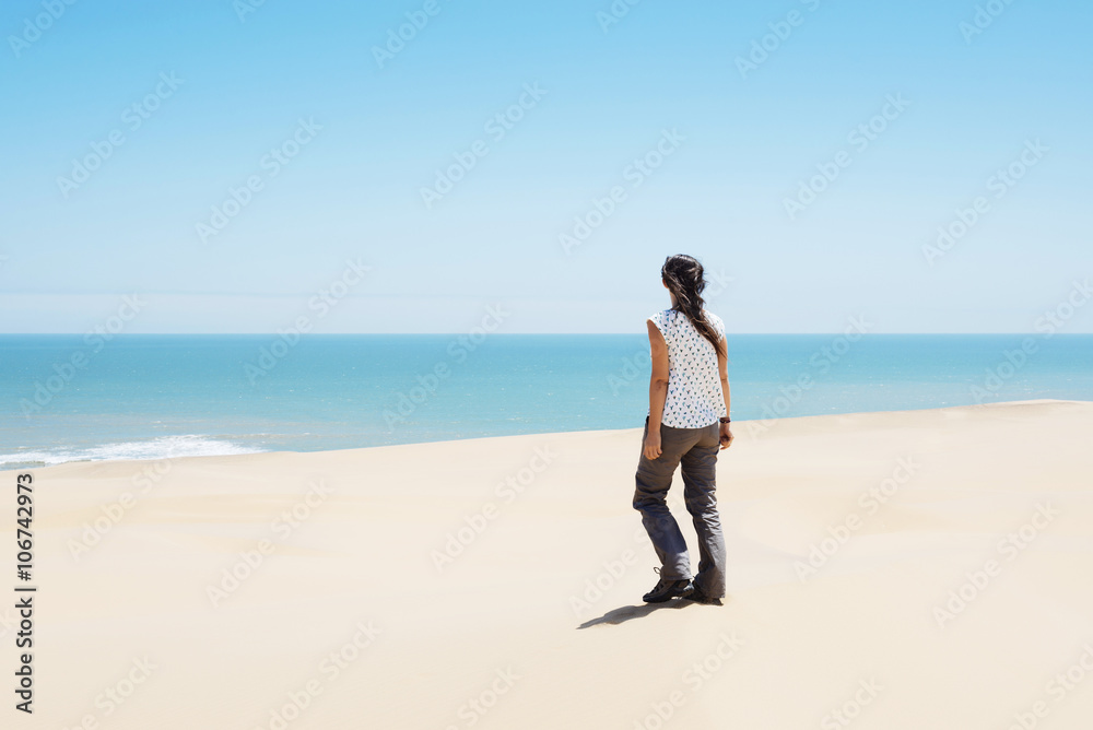 Namibia, Namib desert, Swakopmund, woman walking among the dunes of the desert to the sea Namibia, Namib desert, Swakopmund, woman walking among the dunes of the desert to the sea