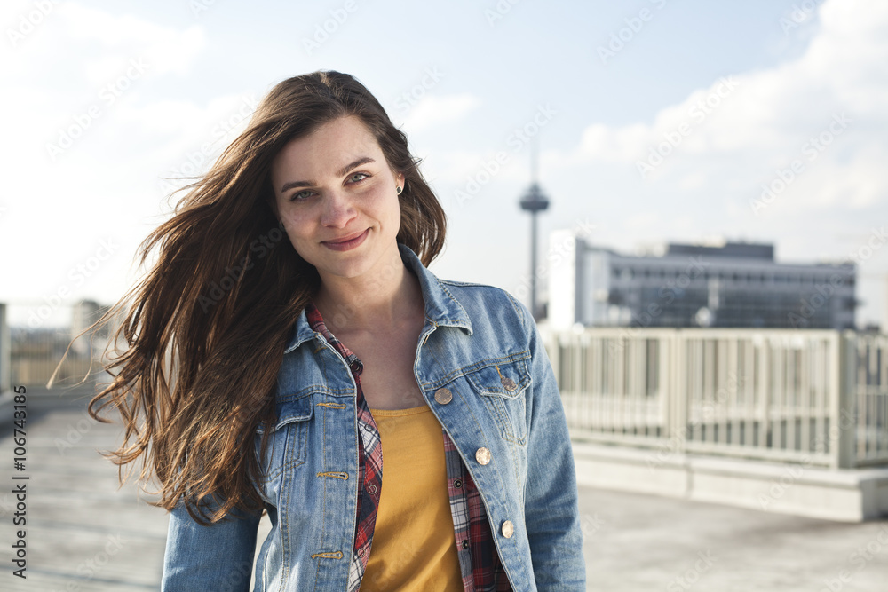 Germany, North Rhine-Westphalia, Cologne, portrait of smiling young woman standing on parking level Germany, North Rhine-Westphalia, Cologne, portrait of smiling young woman standing on parking level