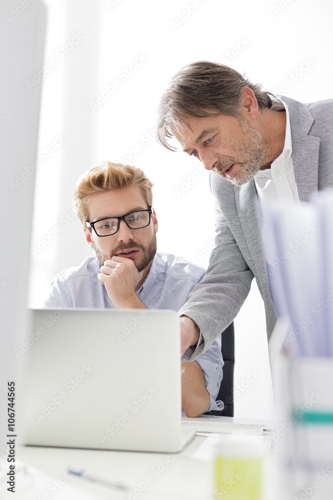 Two businessmen with laptop at desk Two businessmen with laptop at desk