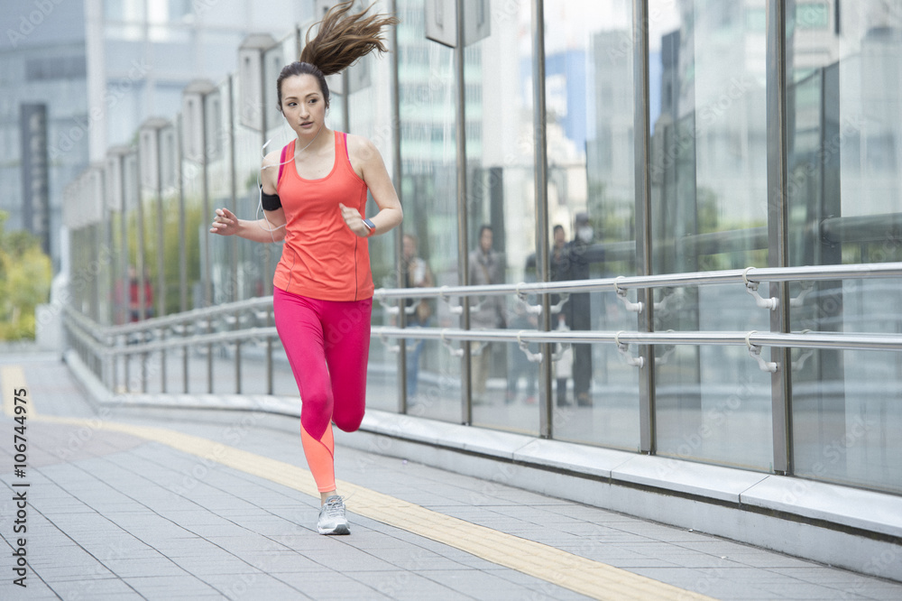 Asian woman jogging with smart watch