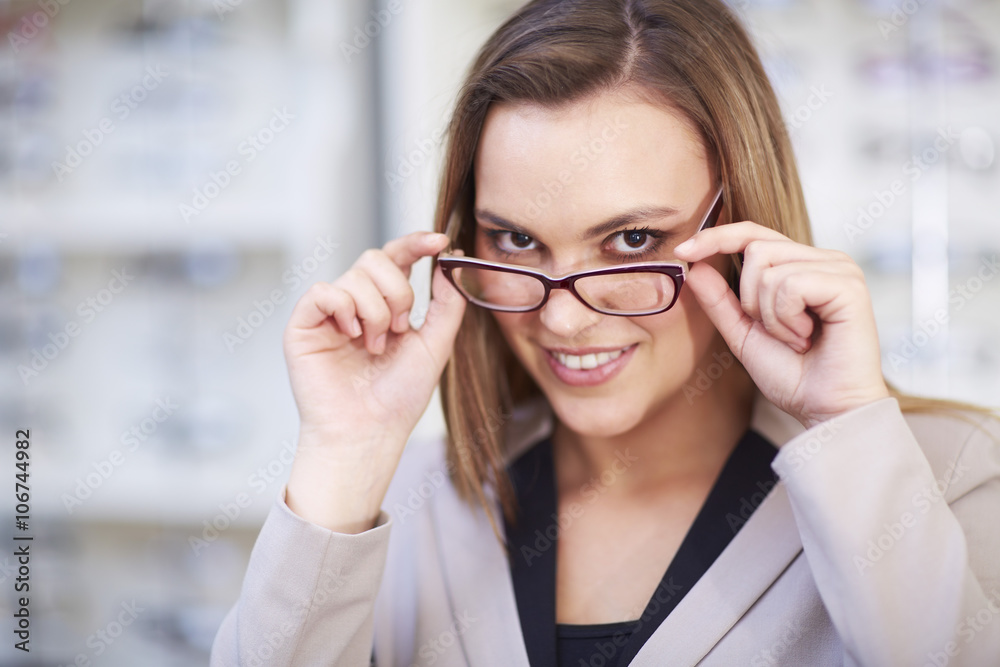Woman at the optician trying on glasses Woman at the optician trying on glasses