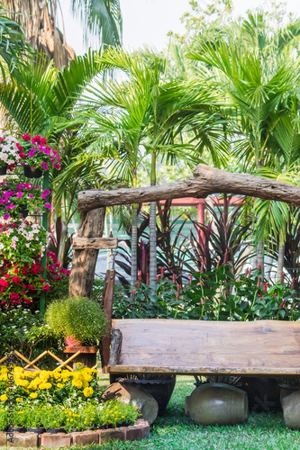 Wood chair in the flowers garden./ Panorama landscape flower garden with lots of colorful blooms and wood chair.
 photo