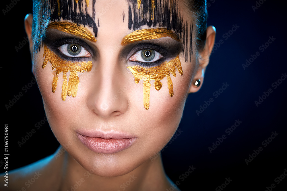 Young woman looking at the camera with fantasy make up face art studio shot. Copy space. High resolution 
